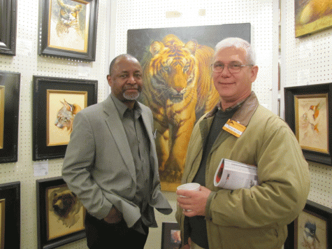 Ezra Tucker standing before one his famous Cat paintings with LTC James DeLuca/The Citadel