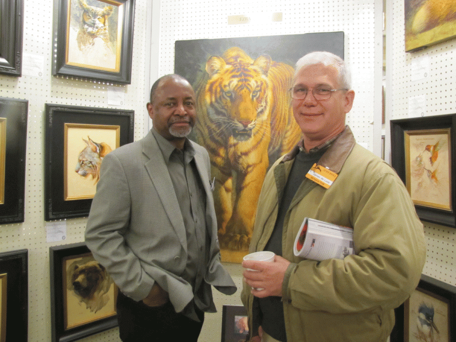 Ezra Tucker standing before one his famous Cat painting with LTC James DeLuca/The Citadel